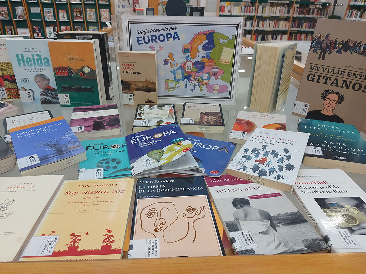 Libros diversos encima de una mesa en una biblioteca
