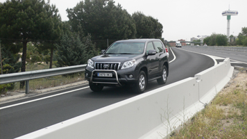 Automóvil de conlor negro transitando por una carretera