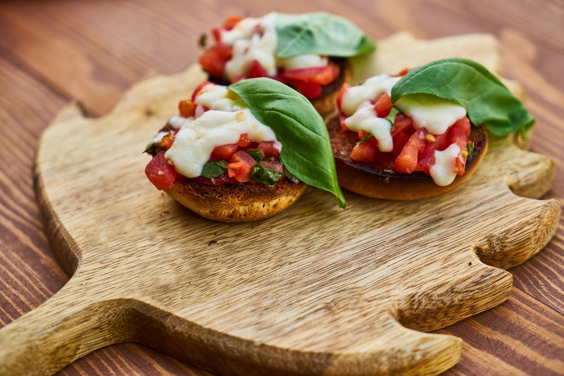 Tabla con panecillos con tomate albahaca y queso