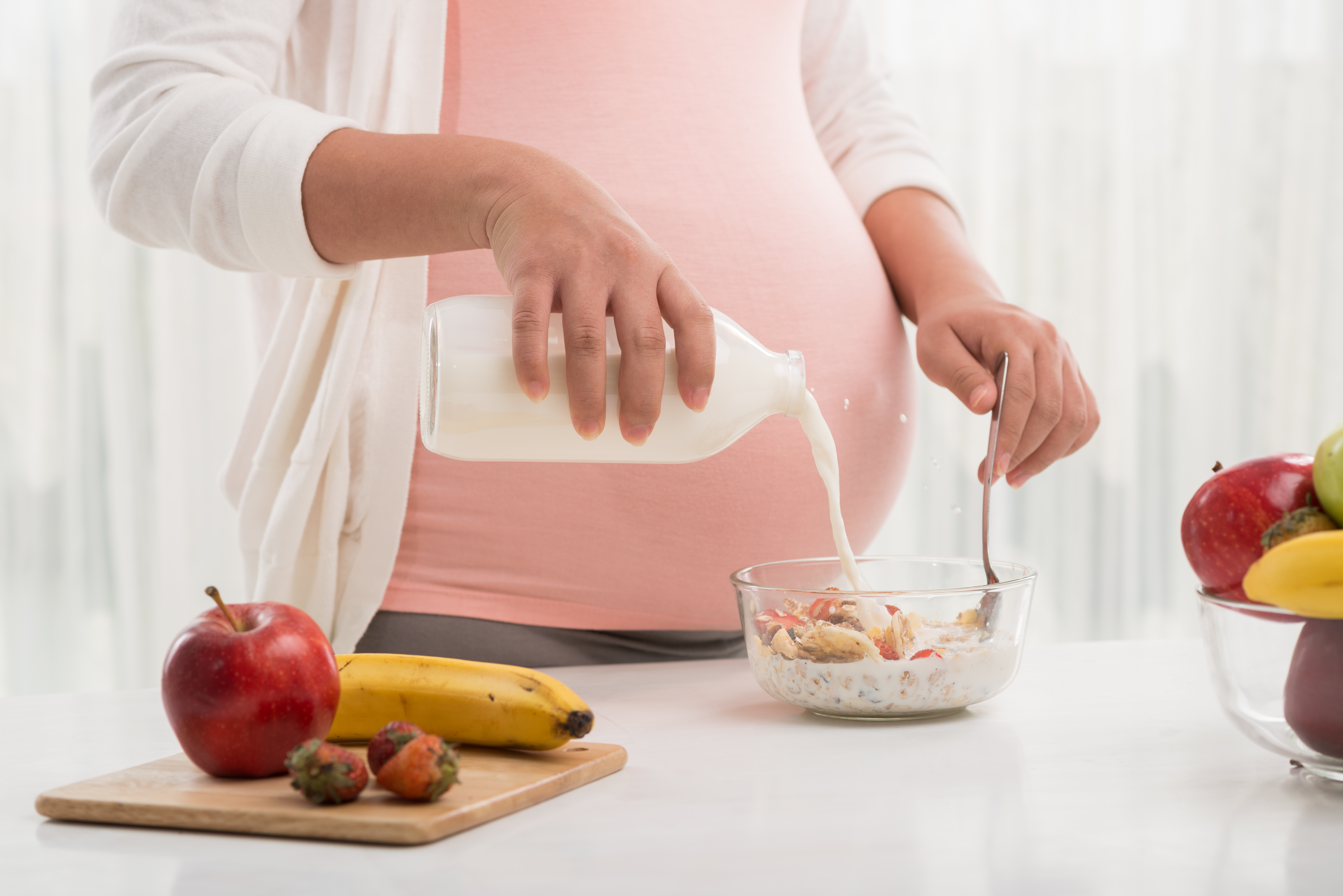 mujer embarazada preparando un cuenco de muesli