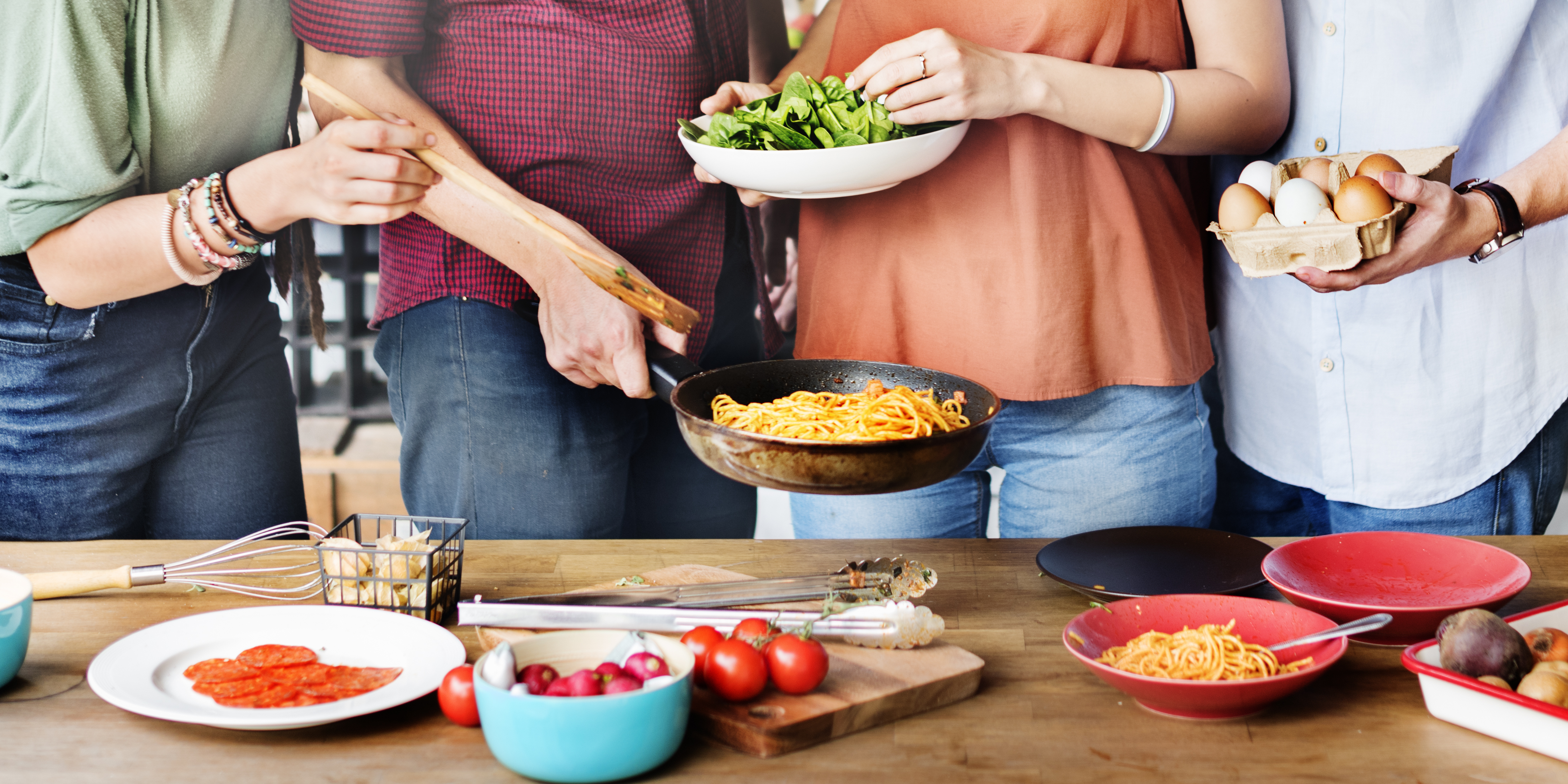 personas preparando una comida con varios ingredientes