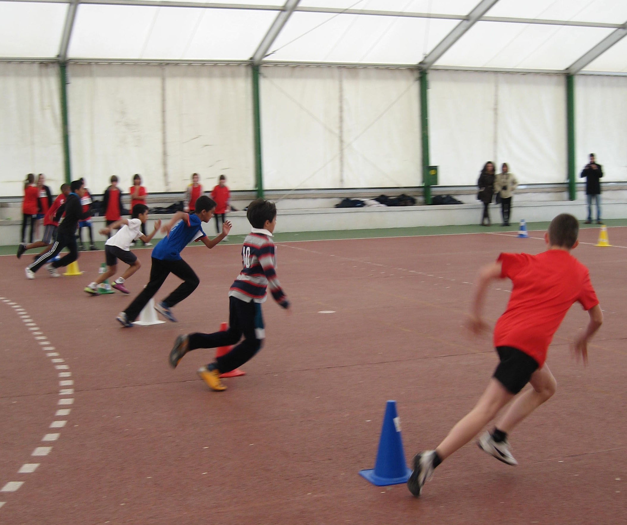 Niños sorteando conos en una actividad deportiva