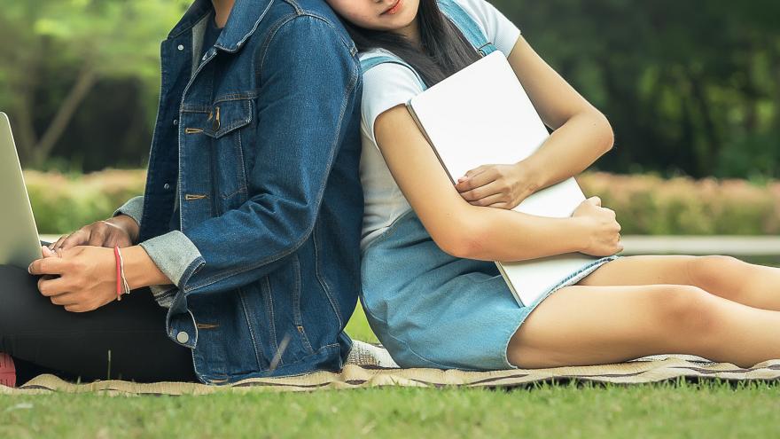 Estudiantes en un parque con sus ordenadores portátiles