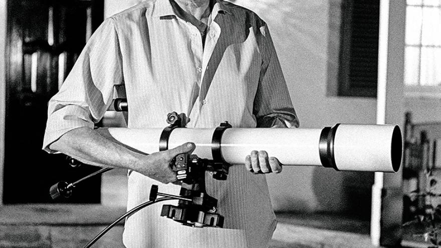 Un hombre portando un pequeño telescópio