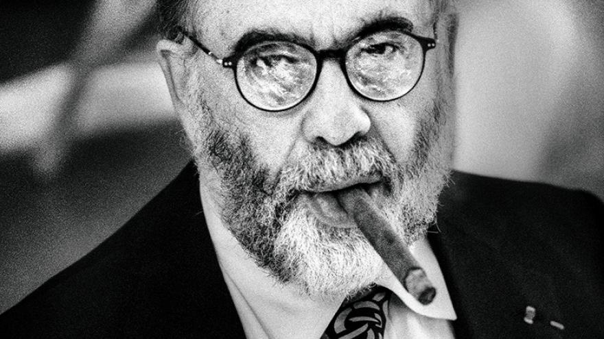 Hombre barbudo y con gafas fumando un puro