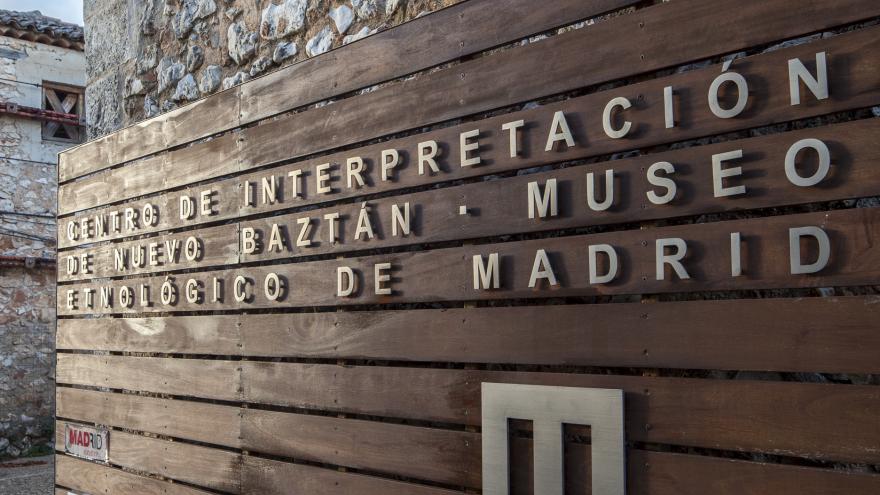 Entrada al centro de Interpretación de Nuevo Baztán Panel de manera en la entrada al Centro de Interpretación de Nuevo Baztán con el nombre y logo del centro en color blanco