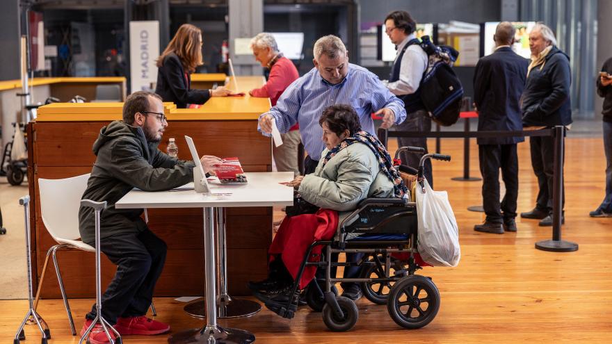Asistente a la Feria recibiendo información en una mesa adaptada
