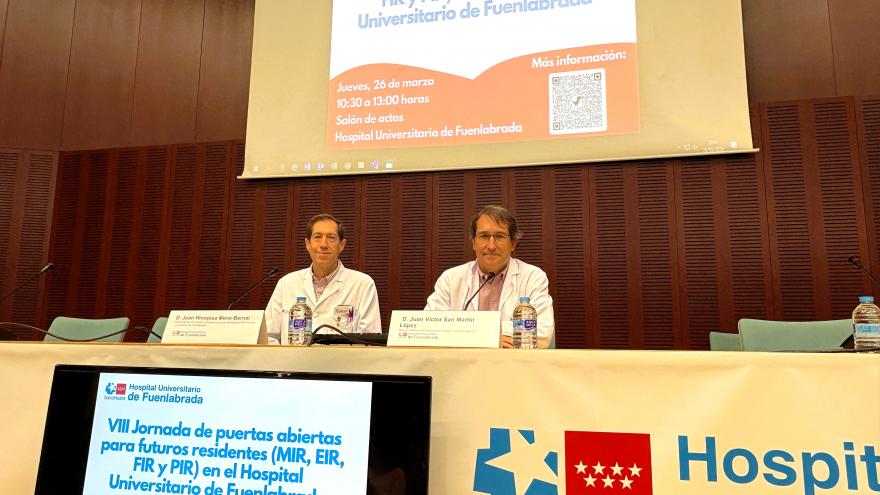 Dos doctores sentados en una mesa antes de hablar en público