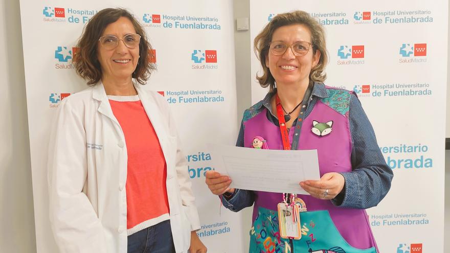 Dos mujeres y una de ellas sostiene un diploma
