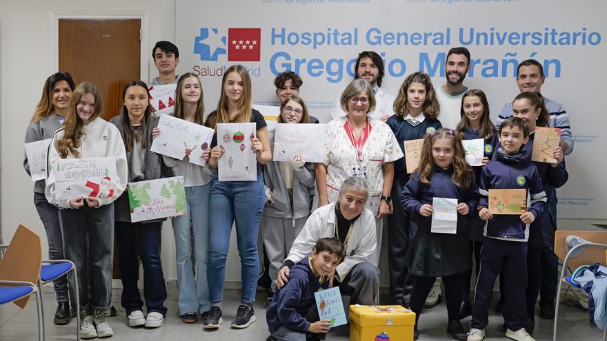 Niños posan con felicitaciones navideñas junto a personal del hospital
