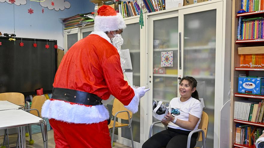 Papá Noel entrega un regalo a una niña 