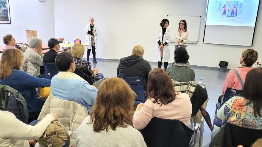 Mujeres en un aula escuchan a la ponente