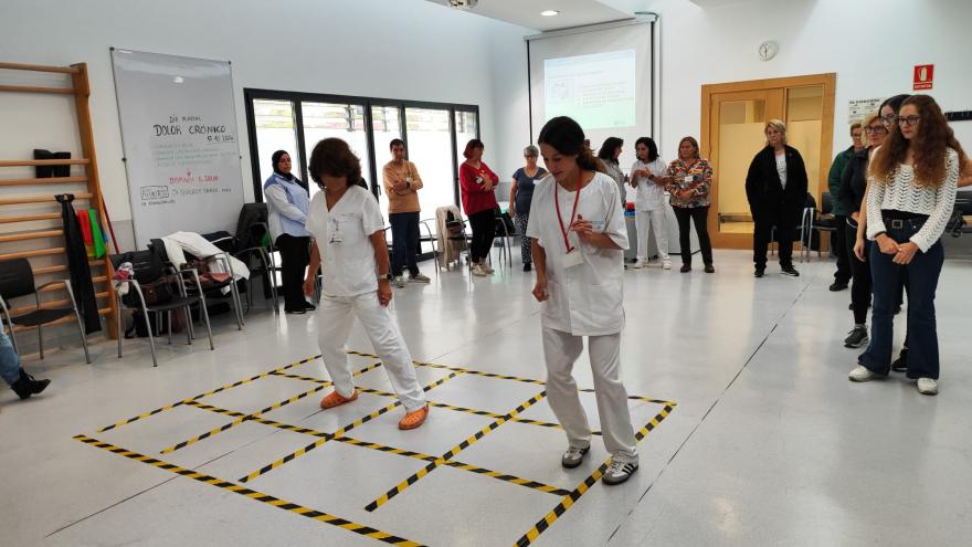 Fisioterapeutas explicando cómo realizar un ejercicio a las usuarios del taller de dolor