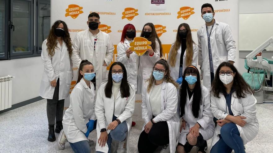 Alumnos posando con trasera equipo médula detrás y escudo en la mano