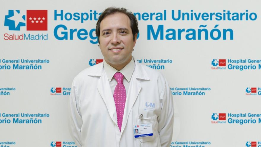 Persona posando para una foto con un photocall detrás