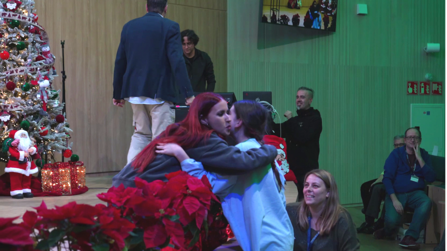 La cantante Vicco al borde del escenario abrazando a una niña