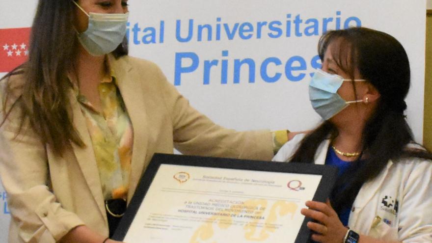 Silvia Jesús (SEN) entregando acreditación a Lydia López, responsable de la Unidad