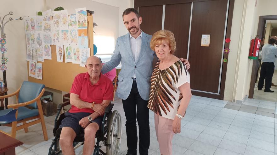 Hombre en silla de ruedas junto a un hombre y mujer de pie