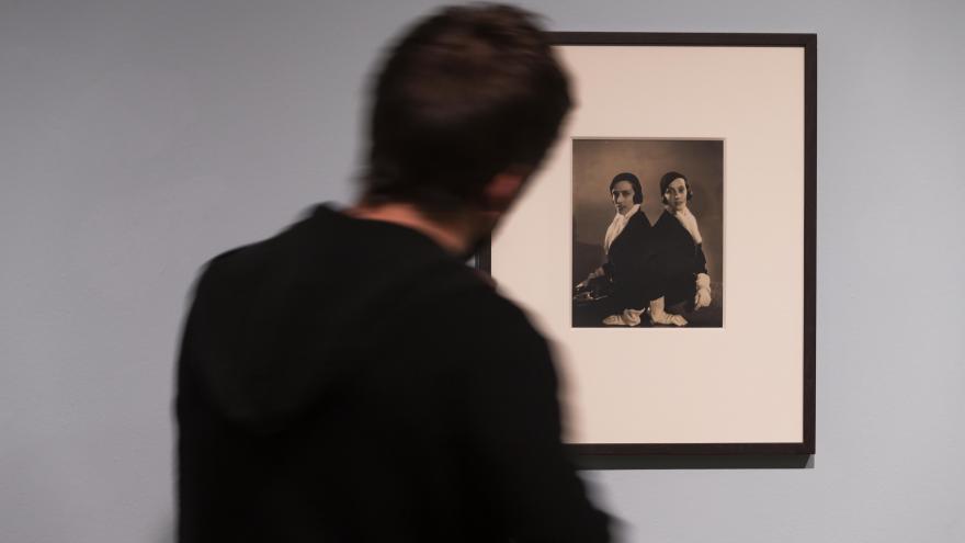 Un hombre ve una de las fotografías de la muestra