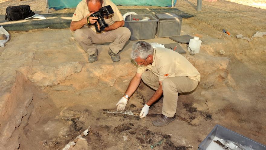 arqueólogo y fotógrafo trabajan sobre el terreno arqueológico