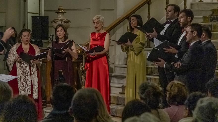 grupo de mujeres y hombres portando carpetas cantando