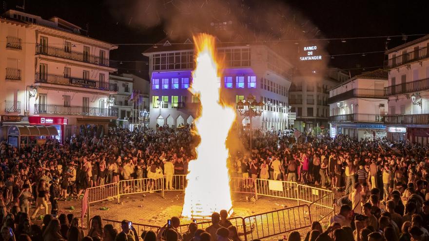 Una plaza en Arganda del Rey llena de gente rodeando una gran hoguera