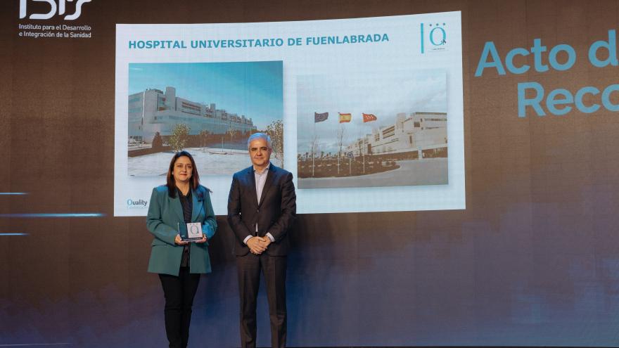 Una mujer y un hombre posan en un escenario durante una gala de premios