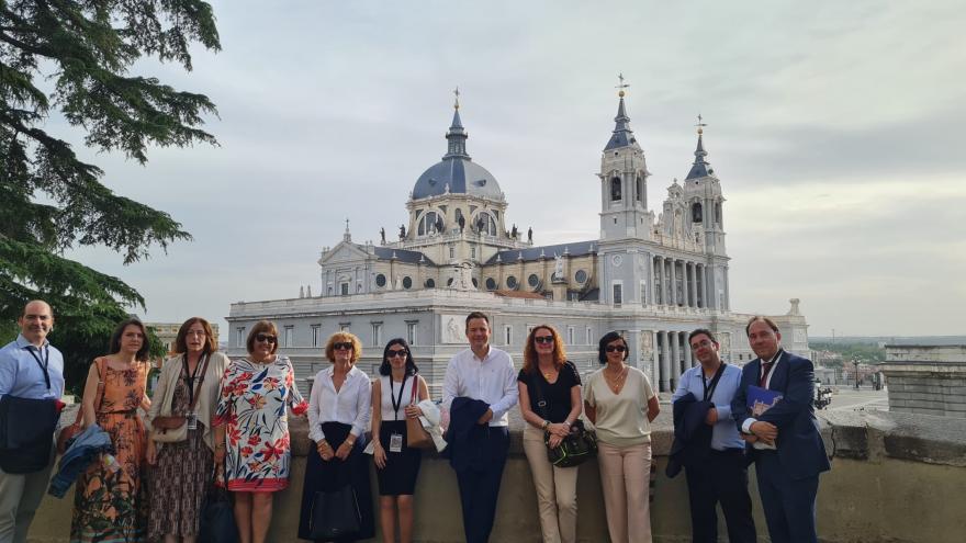 asistentes a la VI Jornada de Buenas Prácticas y aprendizaje mutuo del SNE ante vista del Palacio Real de Madrid