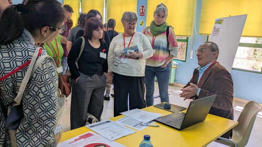 persona dando charla y oyentes alrededor
