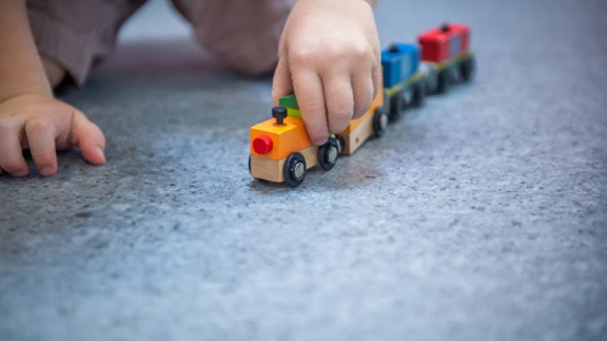 Bebé jugando con tren de madera