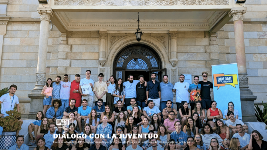 cien jóvenes sonriendo sentados en las escaleras de un edificio 