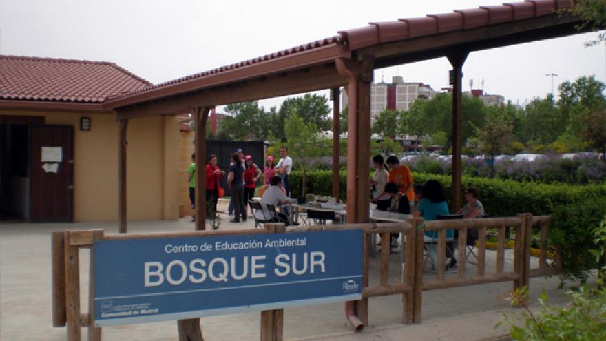 Vista de entrada al centro, cartel de Bosque Sur, camino de entrada con pérgola a la derecha y edificio al fondo