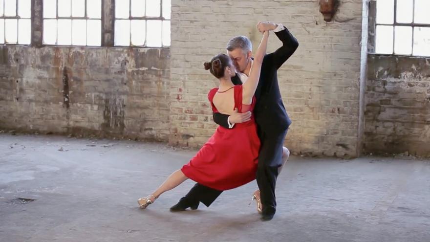 Dos personas en posición de bailes de salón