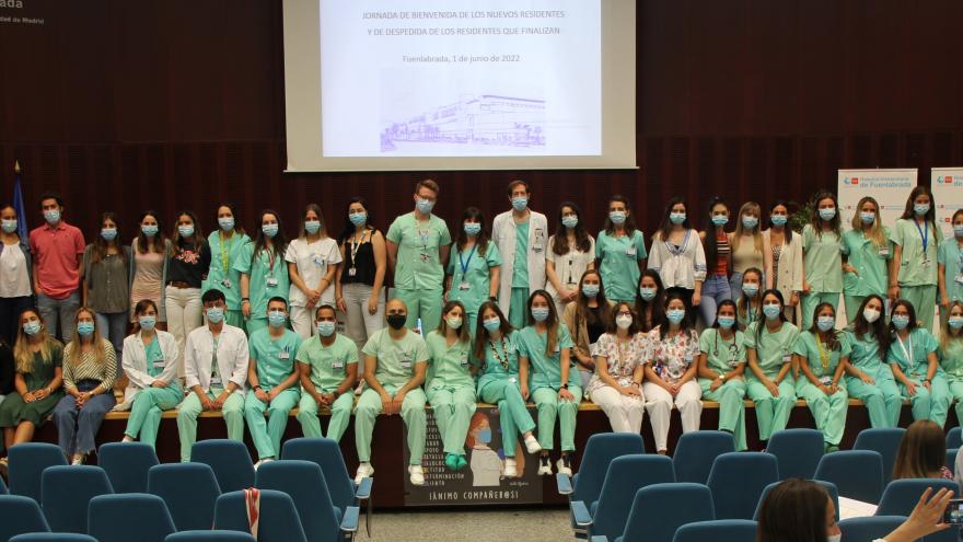Personas sentadas dentro de un salón de actos con uniforme médico