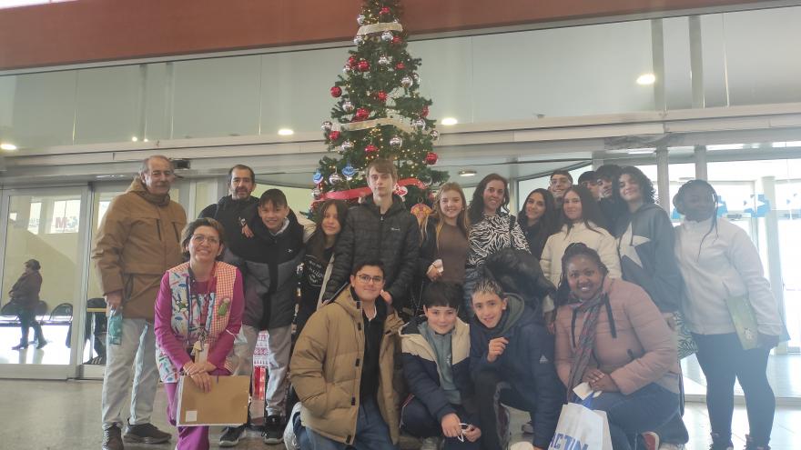 Adolescentes frente a un árbol de navidad