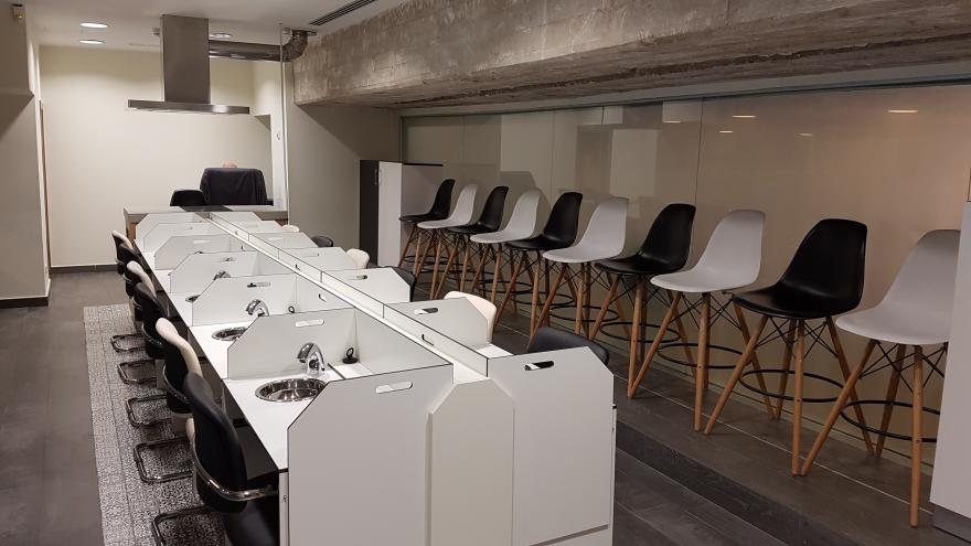 Sala de catas de productos alimentarios con cabinas de análisis sensorial en color blanco y asientos en blanco y negro de modo alterno