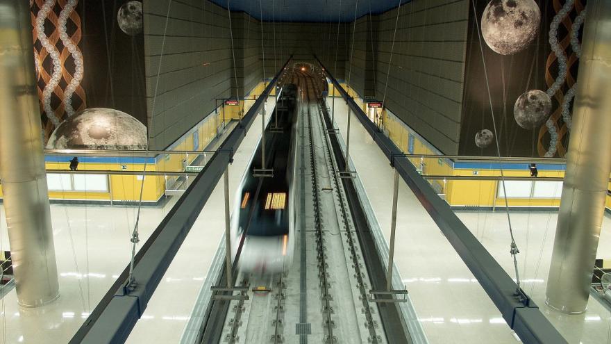 Vista de la estación con el tren en la misma, los murales en los laterales