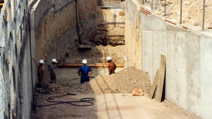 Rampa de acceso, alrededor maquinaria, obreros, camiones