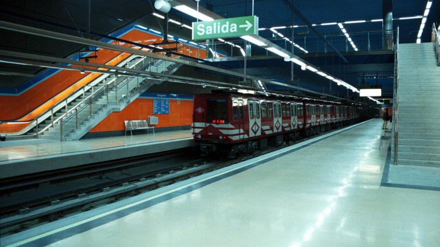 ndenes y cuerpo de escaleras de la estación Congosto con tren saliendo de la estación