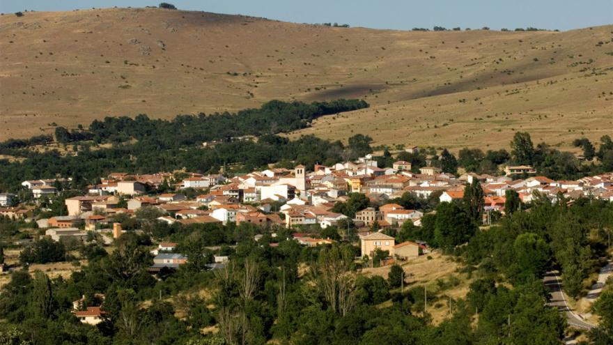 Vista panorámica de Canencia de la Sierra en un valle con colinas al fondo
