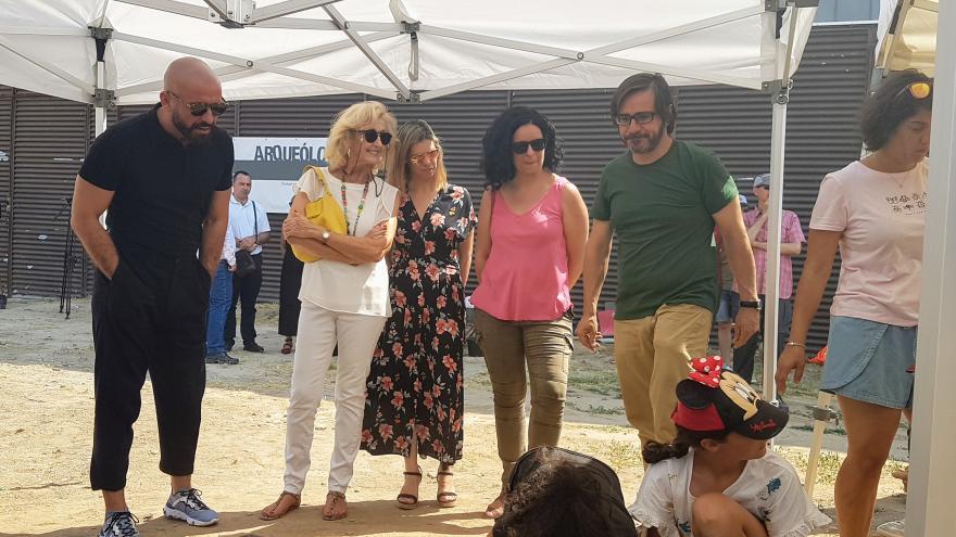 Consejero de cultura observa a los niños en la excavación arqueológica