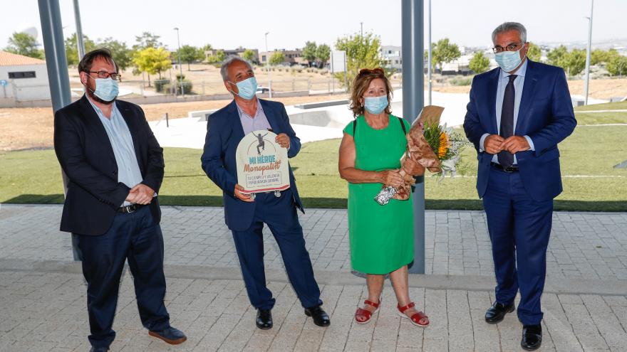 El consejero junto con los padres de Ignacio Echevarría, la madre con un ramo de flores en las manos y el padre con una placa en recuerdo de su hijo