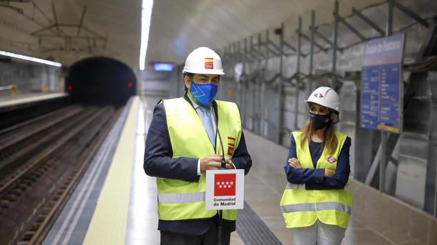 El consejero delante de un micrófono con el logo de la Comunidad de Madrid en el andén de la estación