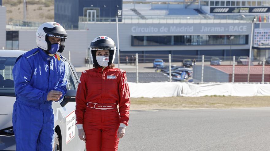 La presidenta con mono de piloto posando junto a los representantes del circuito