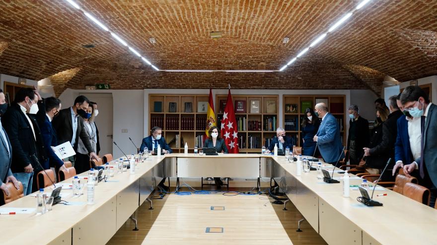 Plano general de la mesa de la reunión con todos los miembros sentados
