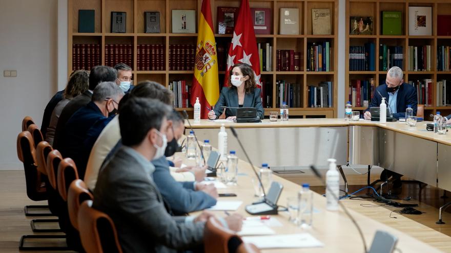 Plano general de la mesa de la reunión con todos los miembros sentados