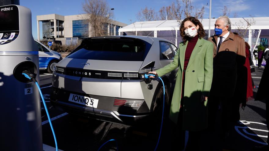 La presidenta enchufando un coche a uno de los puntos de recarga