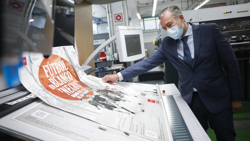 El consejero mirando la impresión de un cartel en el que pone "Fútbol en Blanco y Negro"