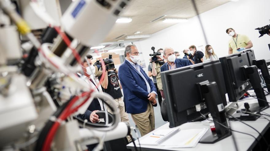 El consejero escucha las explicaciones de los técnicos en una sala con material electrónico