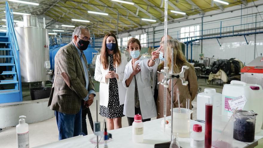 El consejero mirando unos artilugios de laboratorio y atendiendo a la explicación de las profesoras del centro